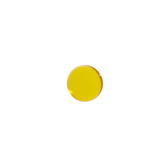 A drop of Augustinus Bader The Face Oil,  showing a yellow liquid on a white background.