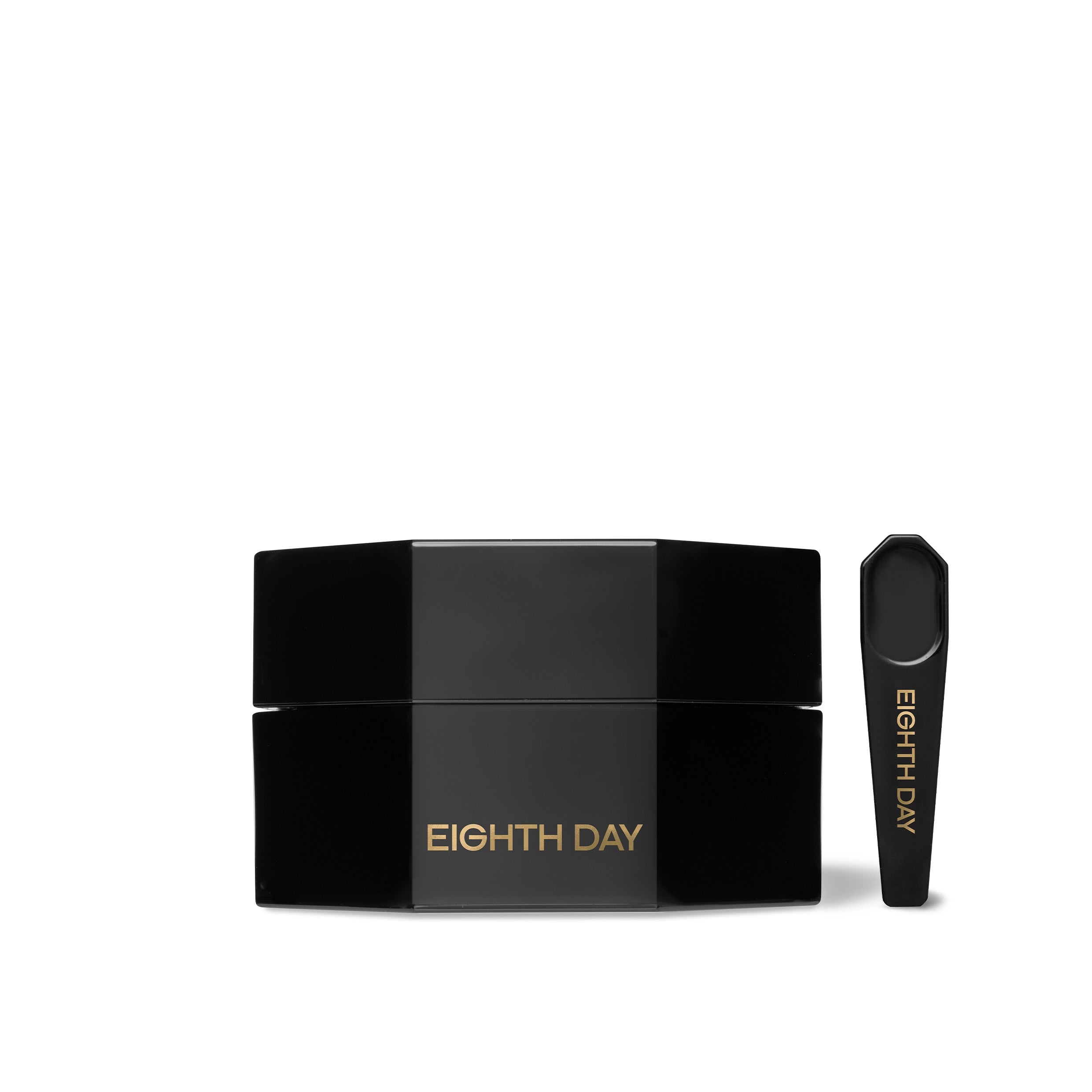 A black jar with a small spoon on the side, labelled with Eighth Day, indicating it is a skin care product.