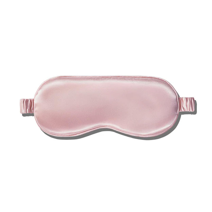 A pink silk sleep mask with an elastic band.