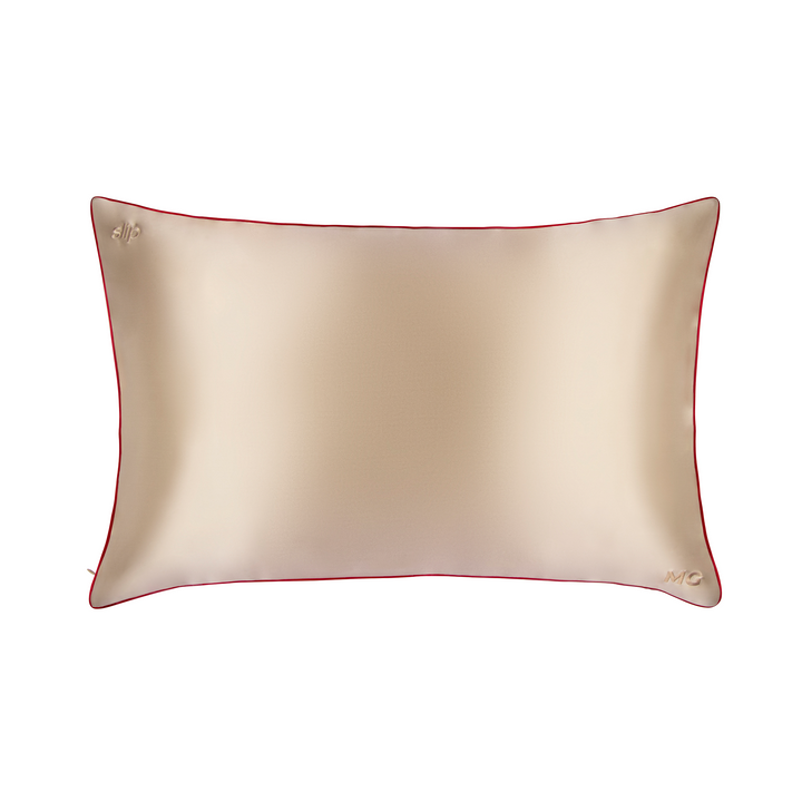 A beige silk pillowcase with a red trim and a visible zipper.