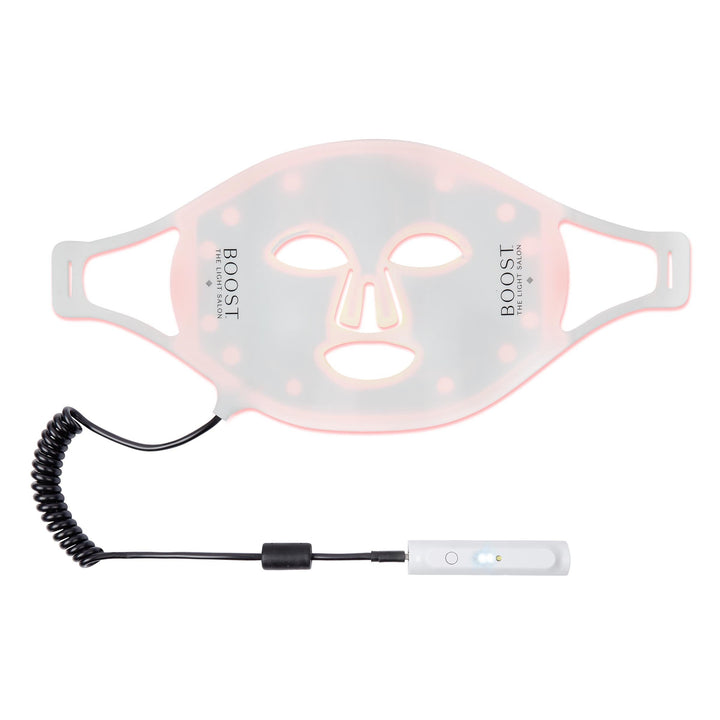 A Boost LED Mask by The Light Salon, a portable skincare device with clinically proven wavelengths to stimulate collagen and elastin synthesis, displayed with a USB charging cable.